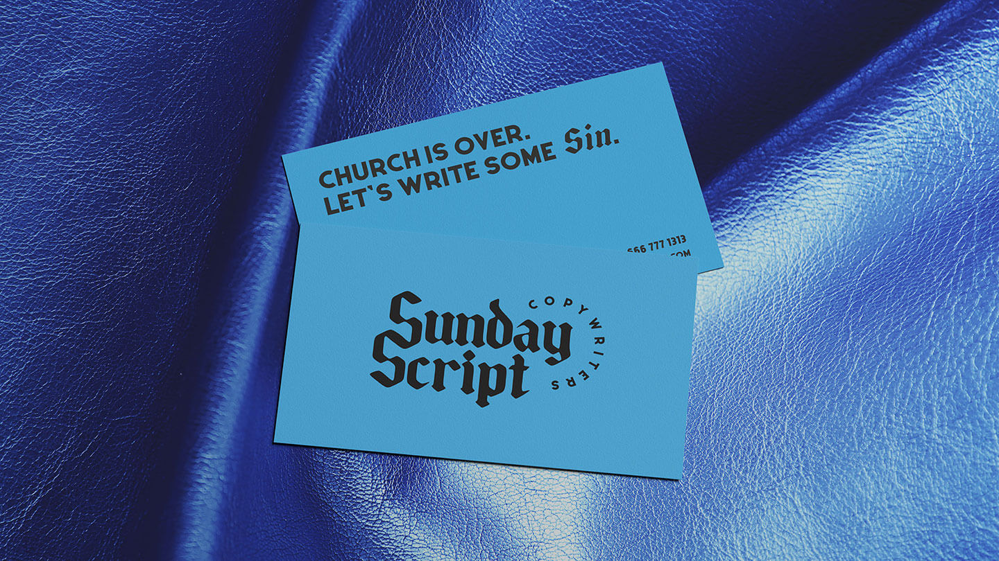Bright blue business cards from Sunday Script on a dark blue leather background