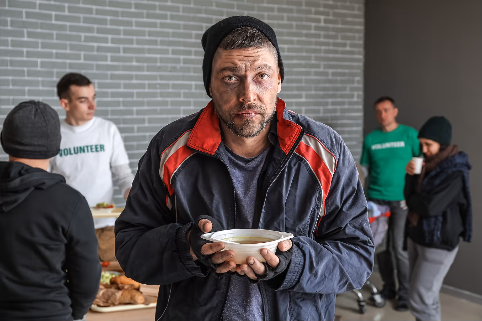 Middle aged homeless man eating noodles
