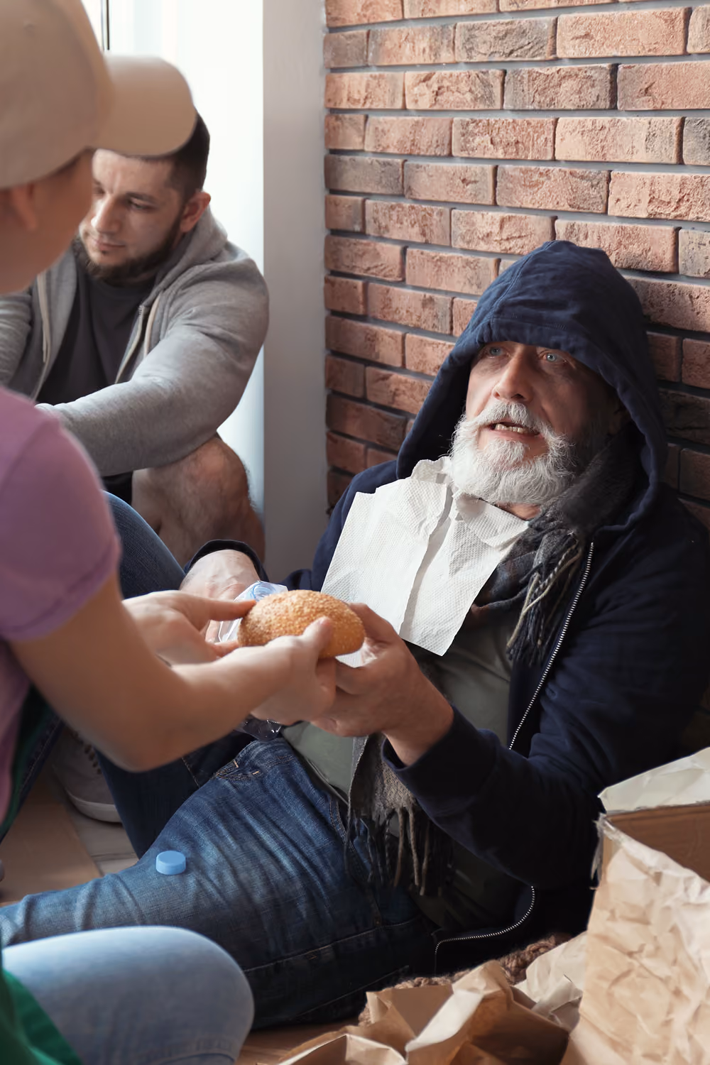 Middle aged homeless man eating noodles