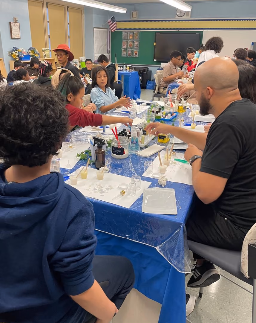 Students and adult conduct hands-on science experiment in classroom