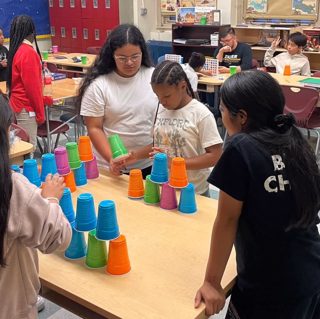 Students stacking colorful plastic cups during a classroom team activity