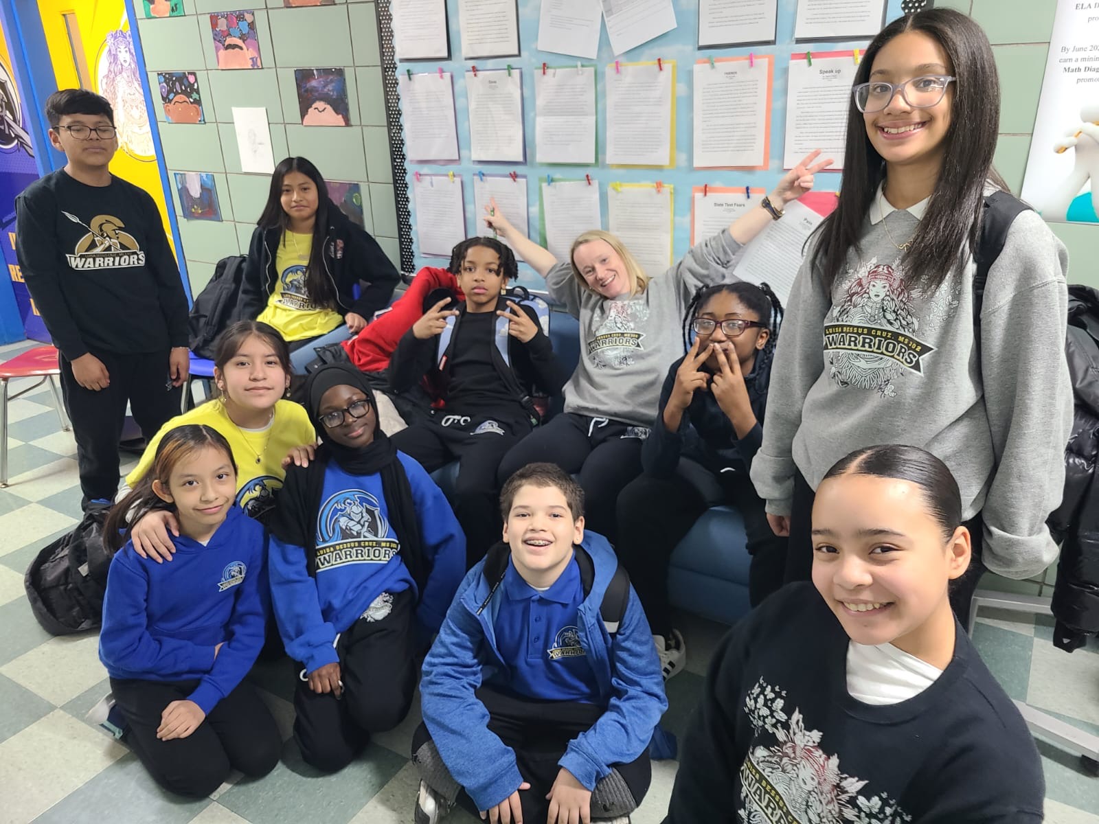 Students and teacher posing together in a Warriors school classroom