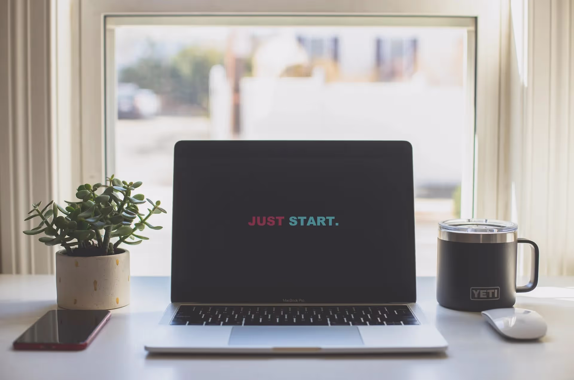 Laptop with "Just Start" on screen.