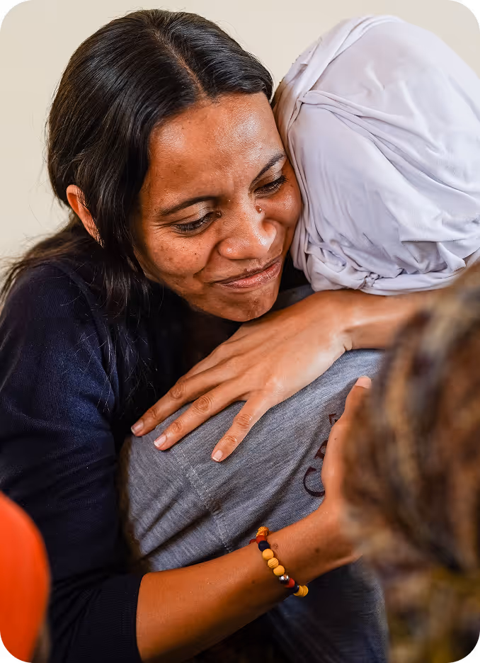 A woman giving another person a hug.