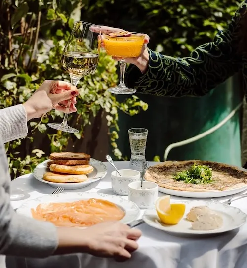 clients entrain de trinquer avec leurs plats sur notre terrasse avec un esprit jardin face à l'arc de triomphe