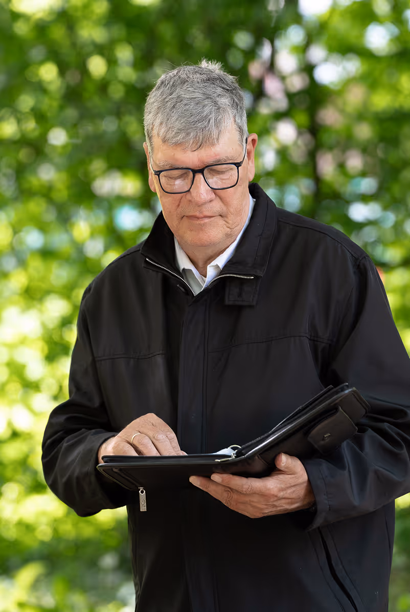 Trauerredner Heiko Rüffer mit Trauerrede in der Hand, Portraitfoto vor einer Abschiedszeremonie