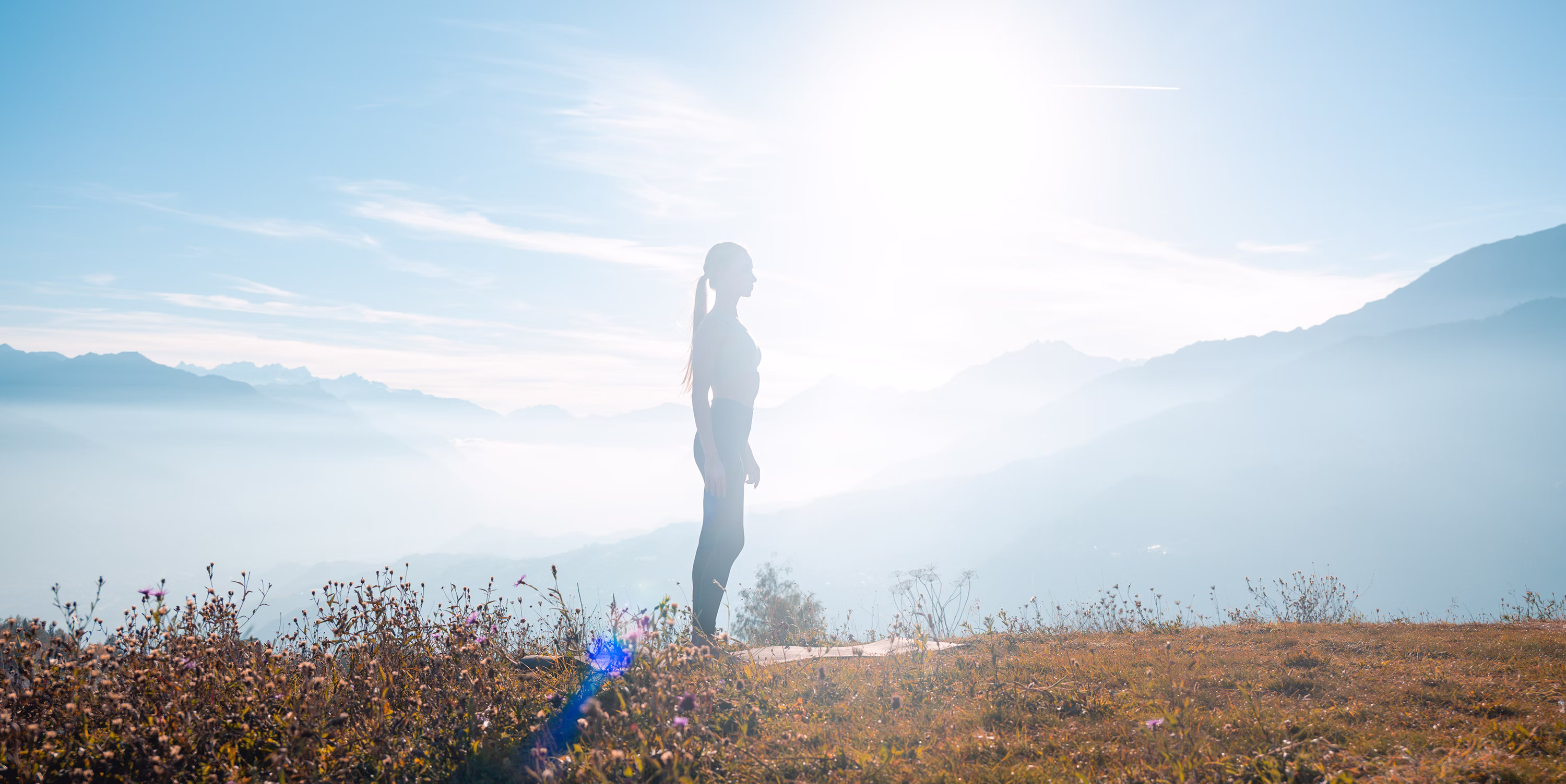 Young woman doing Yoga in the Swiss Alpes, Crans-Montana