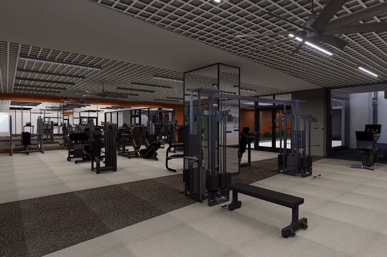 Spacious gym equipped with multiple weight machines, benches, and a dedicated turf area visible through glass, at Continental Tower in Columbus, Ohio.