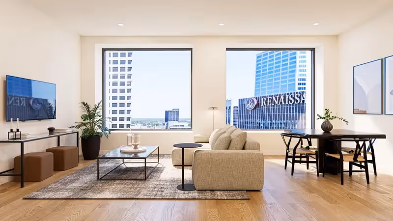 Bright apartment living and dining room with large windows offering panoramic city views of downtown Columbus, Ohio, from Continental Tower.