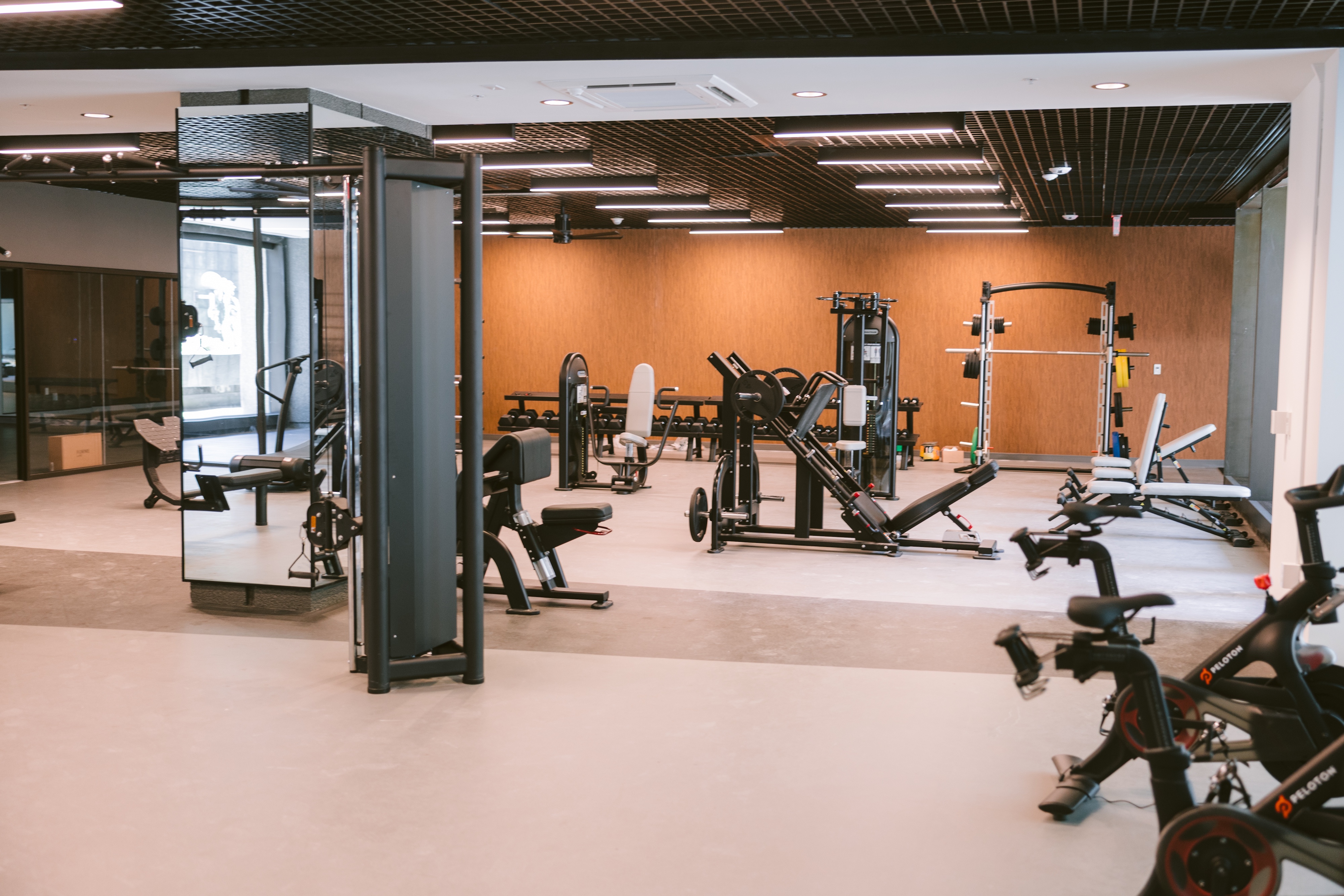 Spacious gym equipped with multiple weight machines, benches, and a dedicated turf area visible through glass, at Continental Tower in Columbus, Ohio.