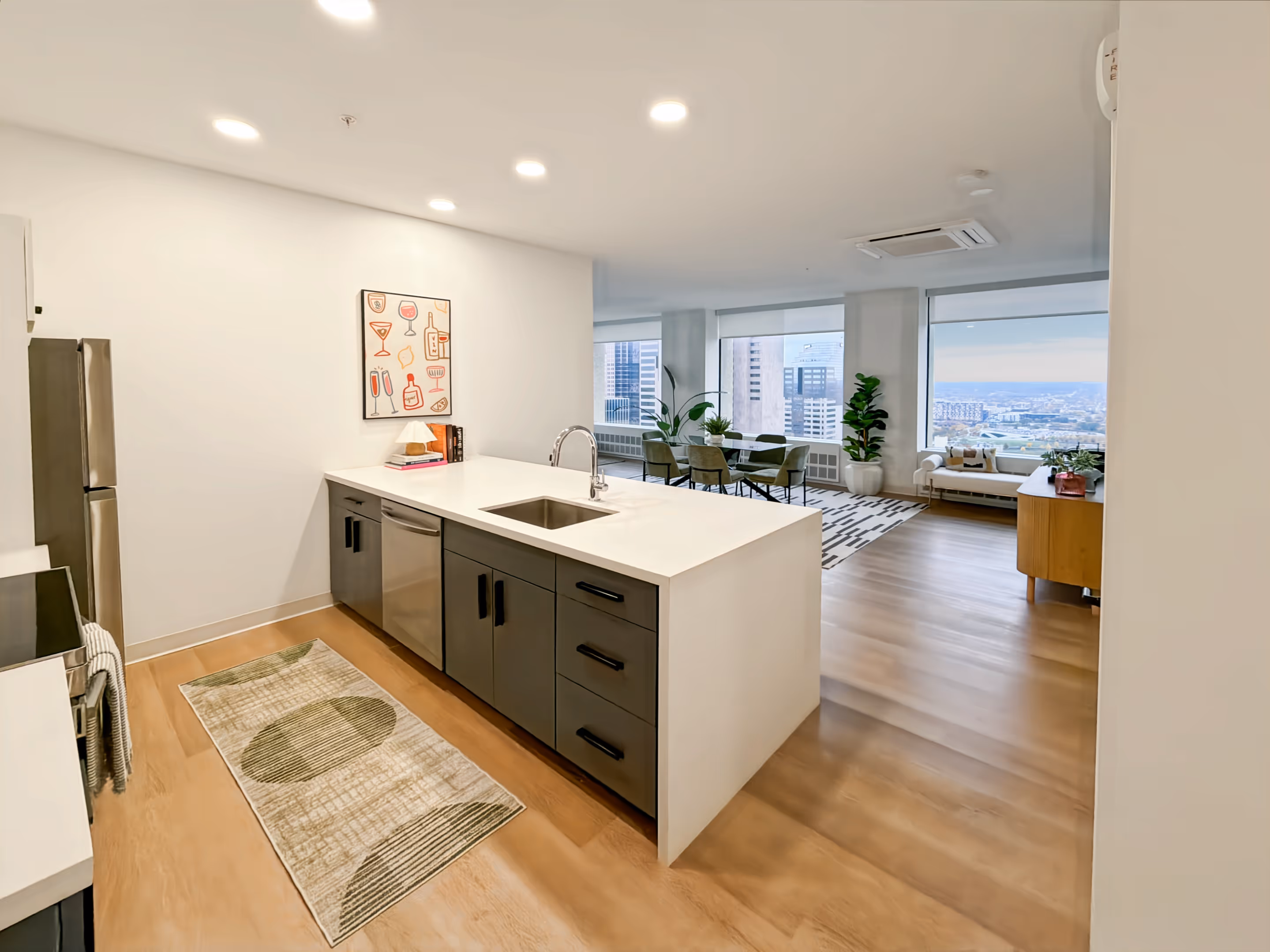 Contemporary kitchen with a large island, blue and white cabinetry, and stainless steel appliances, typical of apartments at Continental Tower in Columbus, Ohio.
