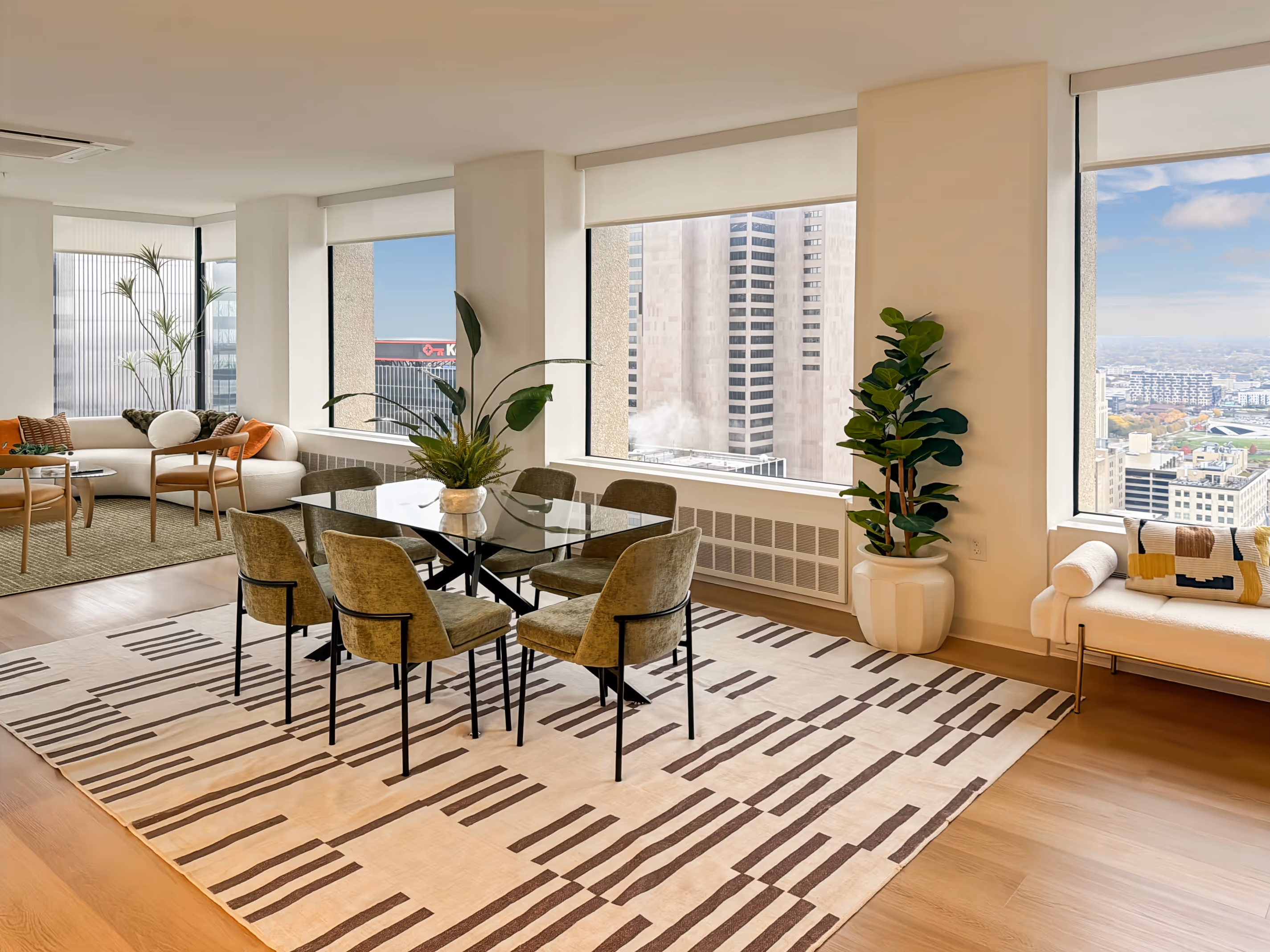 Bright apartment living and dining room with large windows offering panoramic city views of downtown Columbus, Ohio, from Continental Tower.