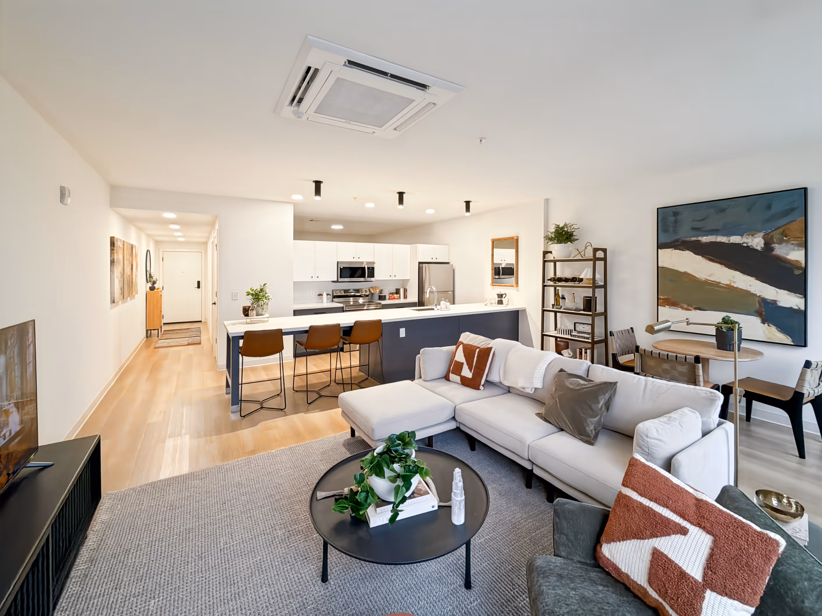 Contemporary kitchen with a large island, blue and white cabinetry, and stainless steel appliances, typical of apartments at Continental Tower in Columbus, Ohio.