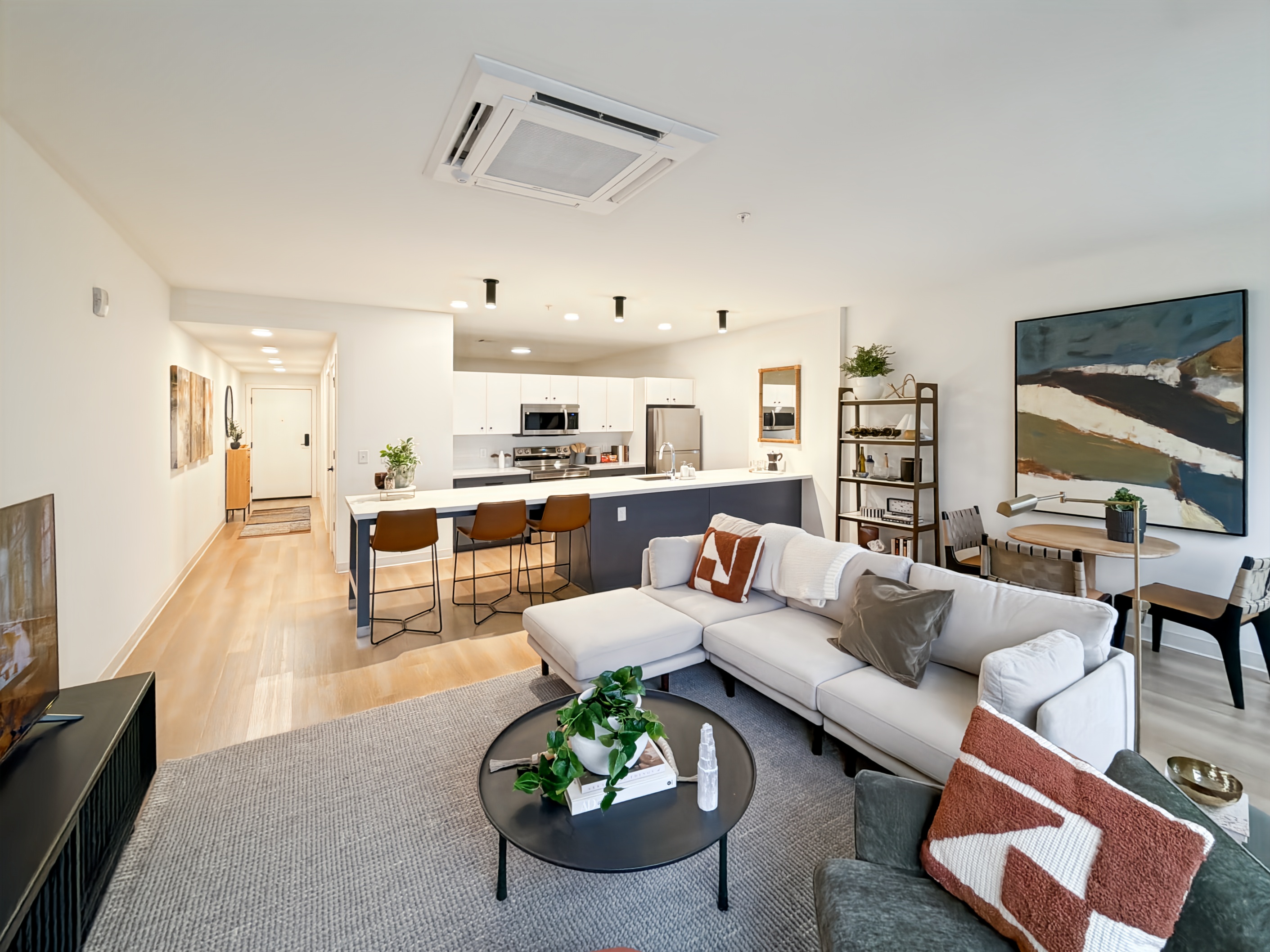 Contemporary kitchen with a large island, blue and white cabinetry, and stainless steel appliances, typical of apartments at Continental Tower in Columbus, Ohio.