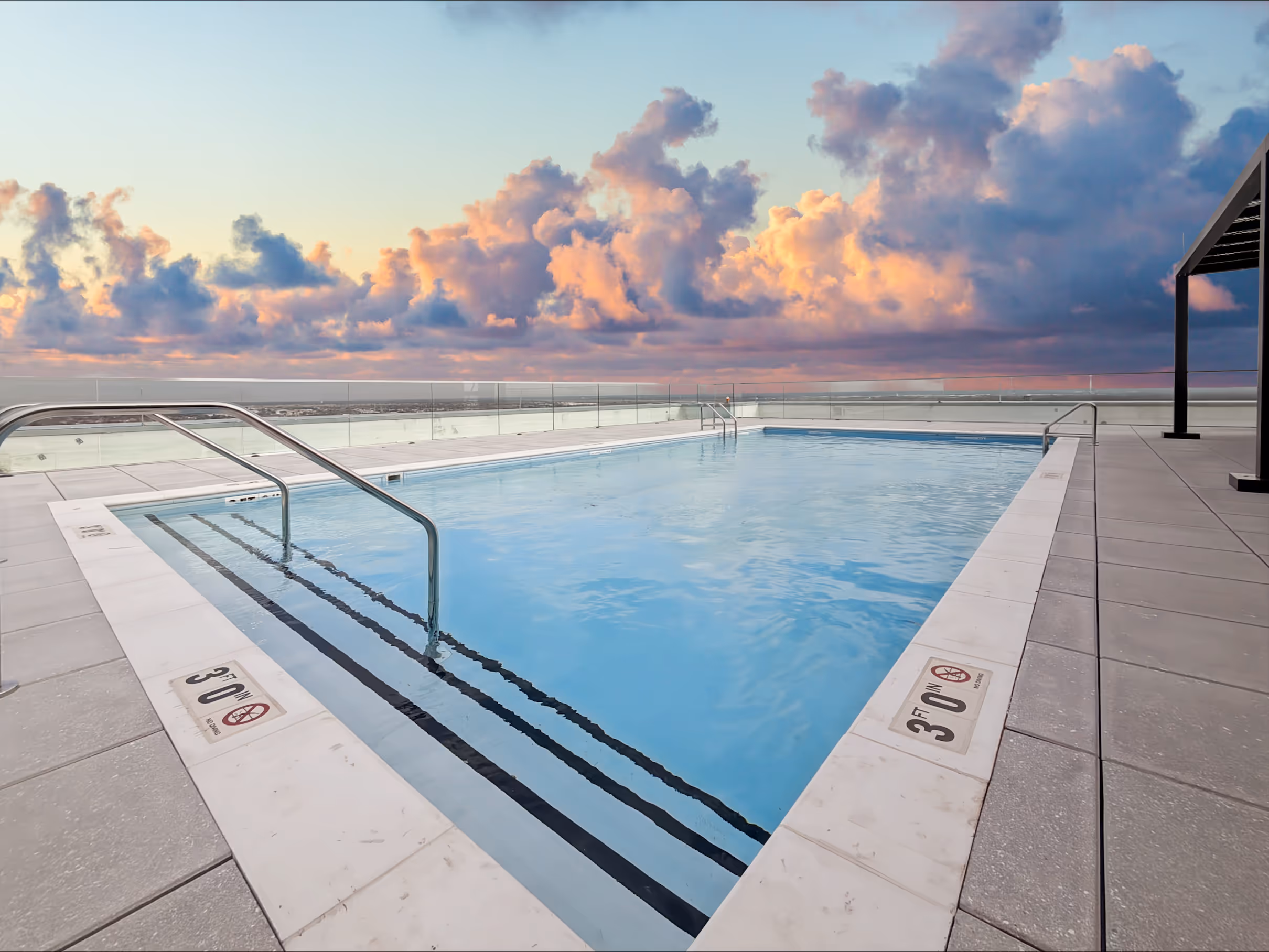 Stunning rooftop swimming pool and lounge deck with shaded cabanas, offering urban views from Continental Tower in Columbus, Ohio.