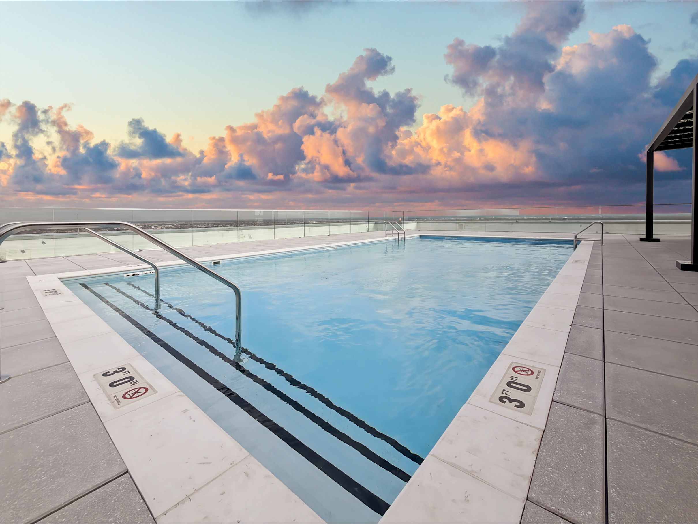 Stunning rooftop swimming pool and lounge deck with shaded cabanas, offering urban views from Continental Tower in Columbus, Ohio.
