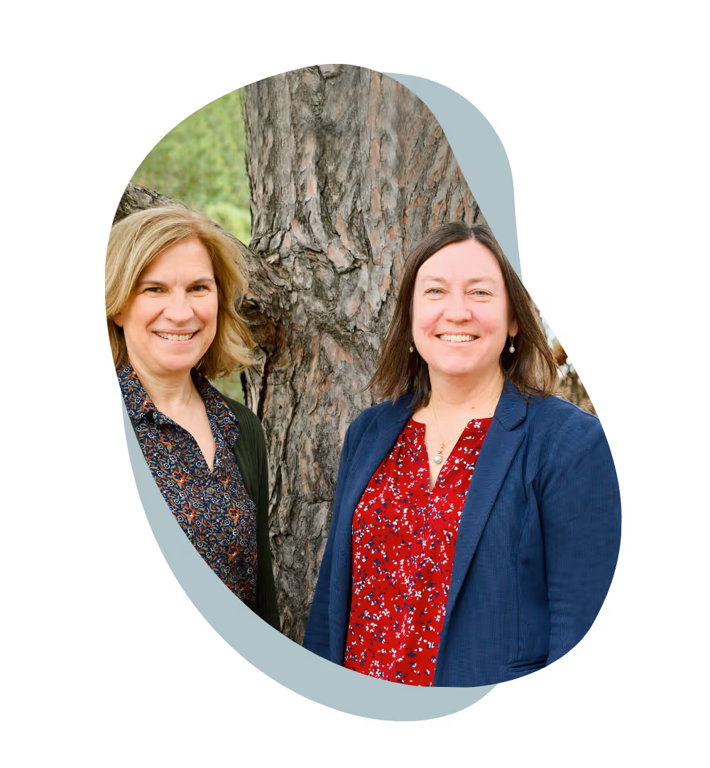An asymmetrical, ellipsoid-shaped photo of Professors Patricia Soranno and Kendra Spence Cheruvelil standing side-by-side outdoors. They are positioned in front of a large tree.
