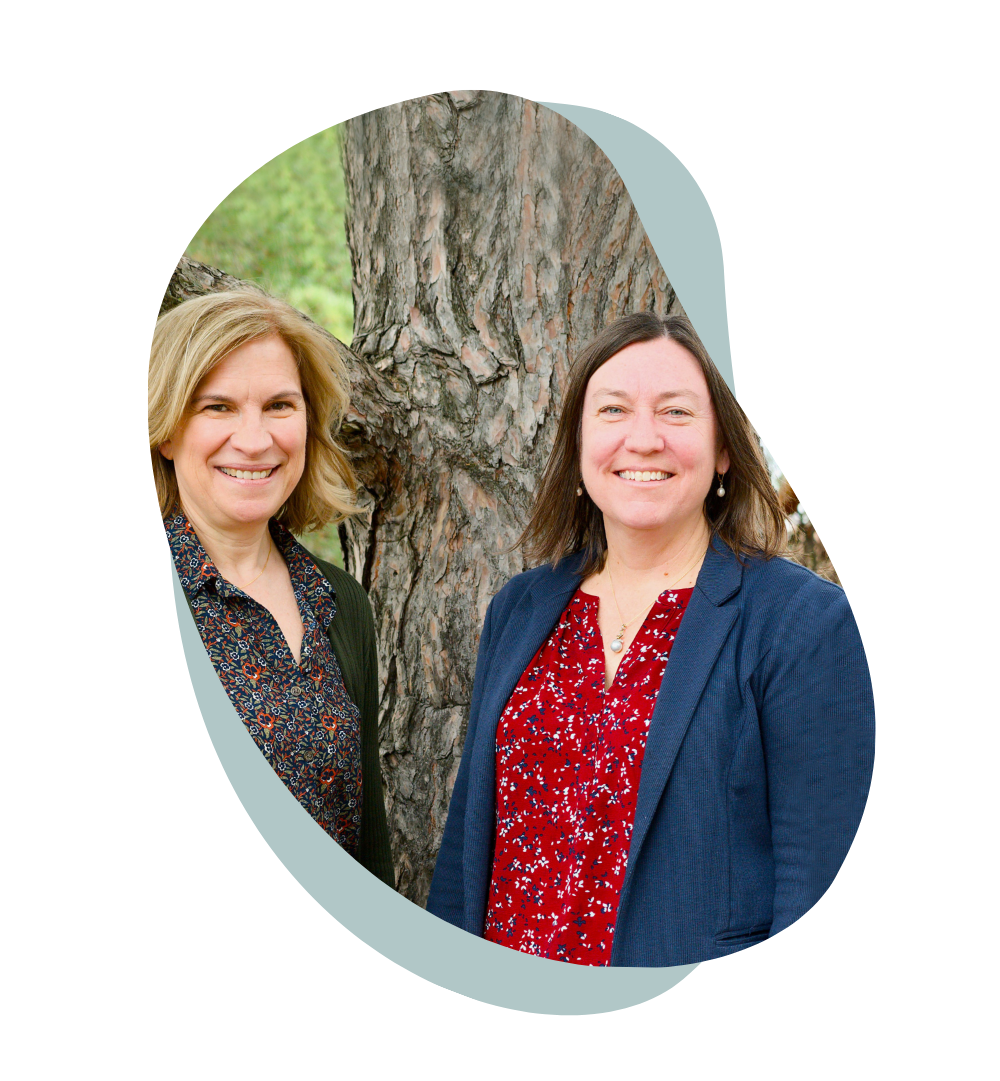 An asymmetrical, ellipsoid-shaped photo of Professors Patricia Soranno and Kendra Spence Cheruvelil standing side-by-side outdoors. They are positioned in front of a large tree.