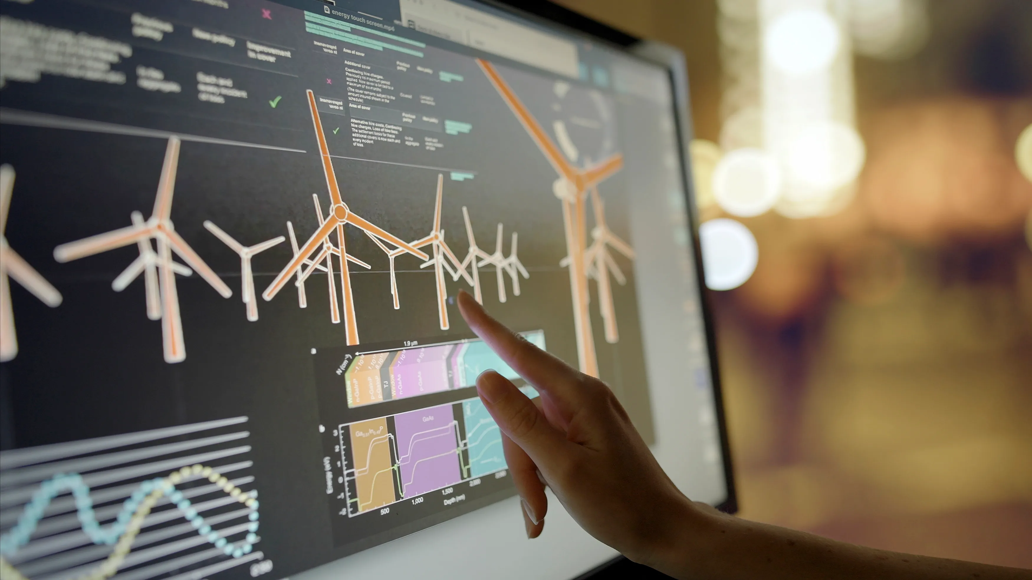 Hand pointing at wind turbine performance data on a touchscreen dashboard