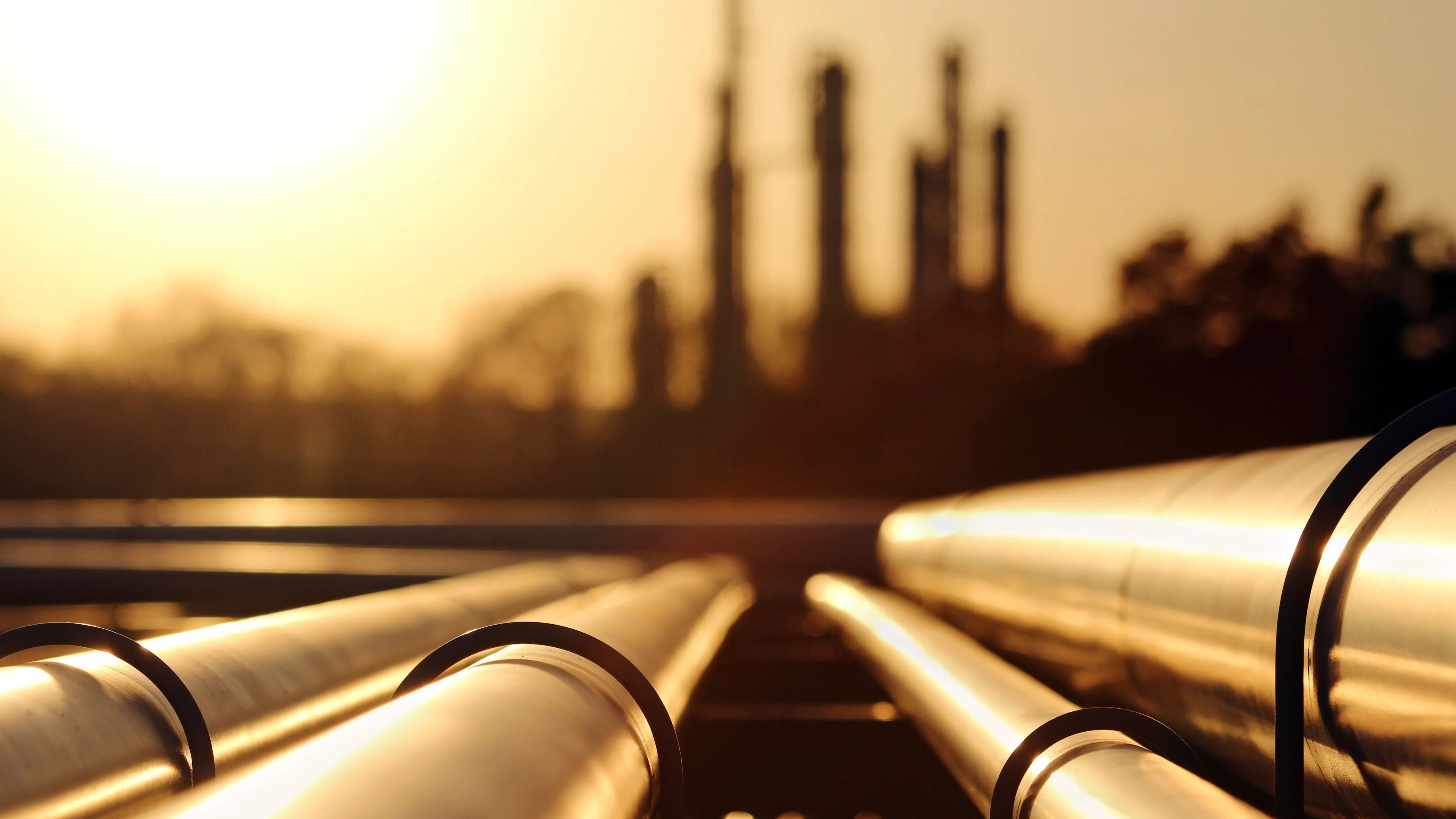 Close-up of pipeline at an oil and gas facility at sunset