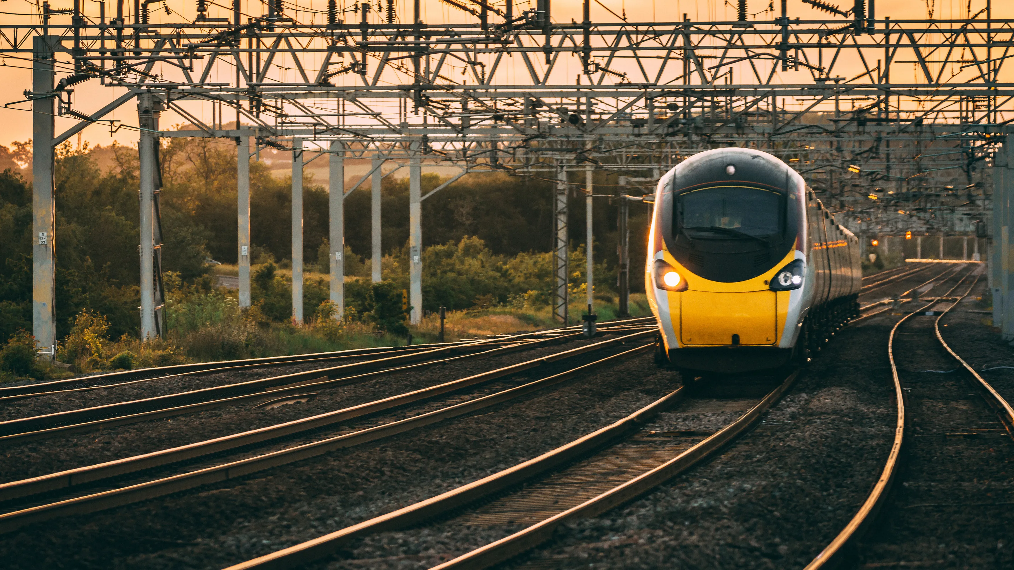 High-speed train on railway tracks with overhead power lines