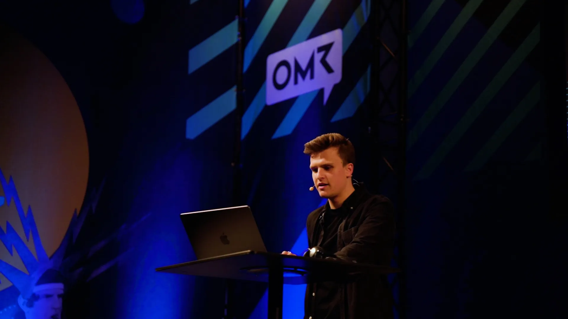 A man giving a presentation with a laptop in front of him.