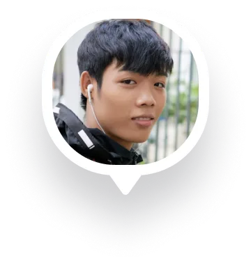 Young man with black hair wearing earphones and a black jacket looking at the camera.