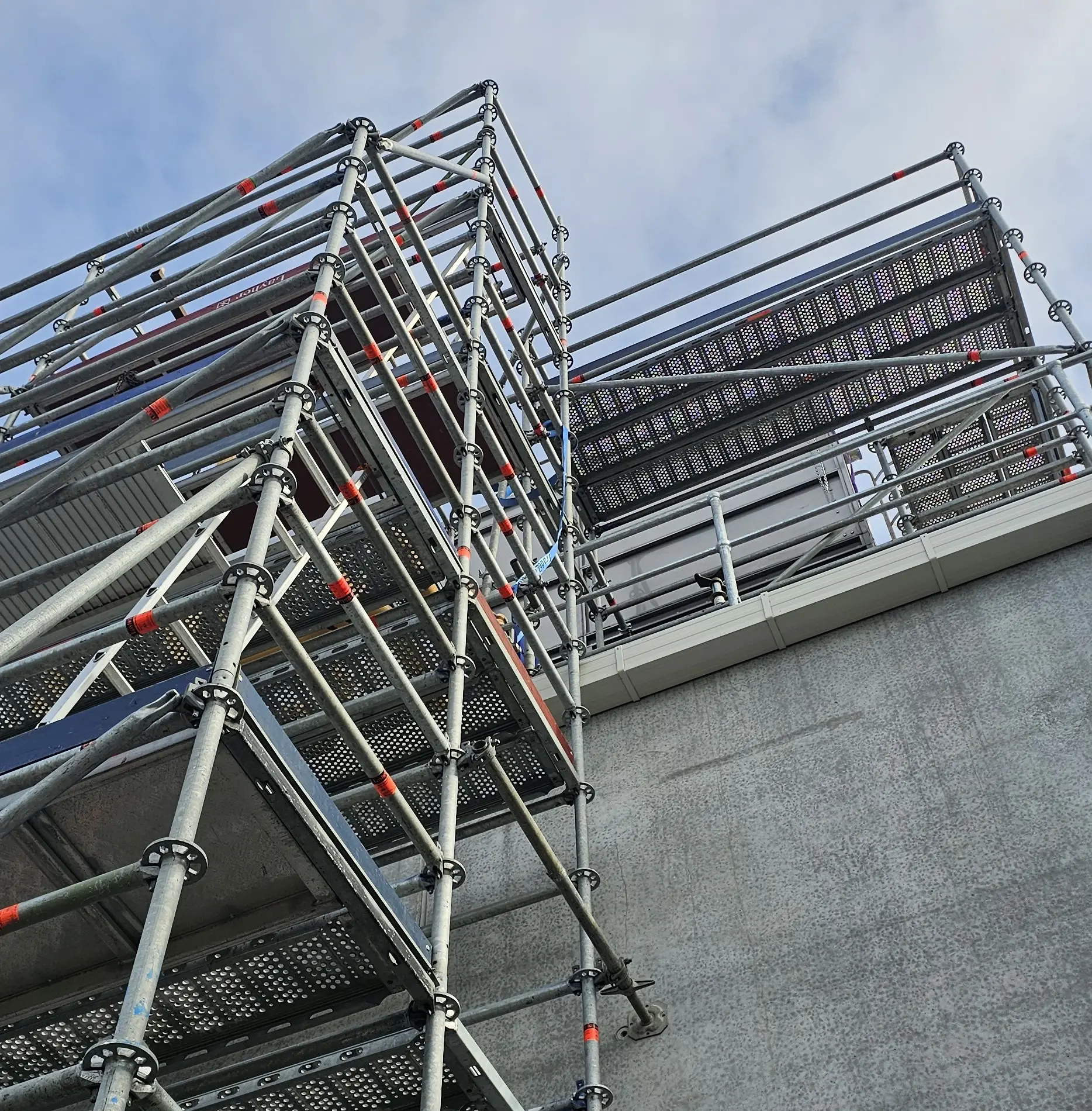 Barred Up Scaffolding erected around a two-story house during exterior painting or renovation work