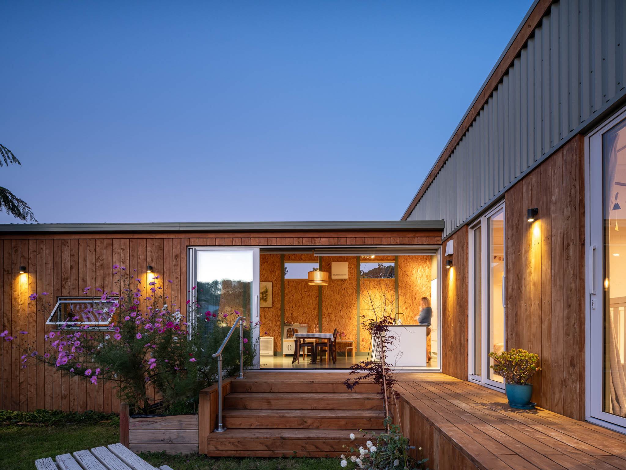 Exterior of L-shaped small, modular home with wooden exterior