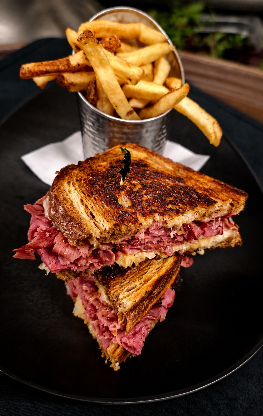 Reuben sandwich on marble rye with a tin of fries