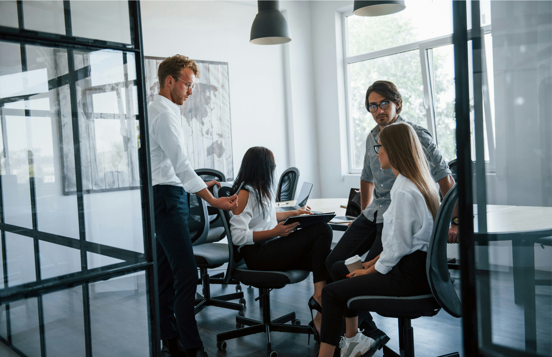 Photograph of four people having a discussion in an office meeting room.