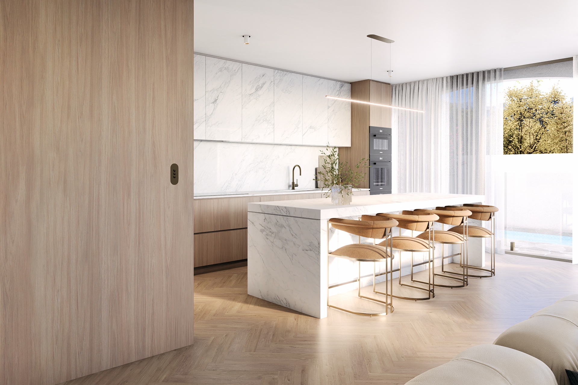 A modern kitchen with a marble island and bar stools.