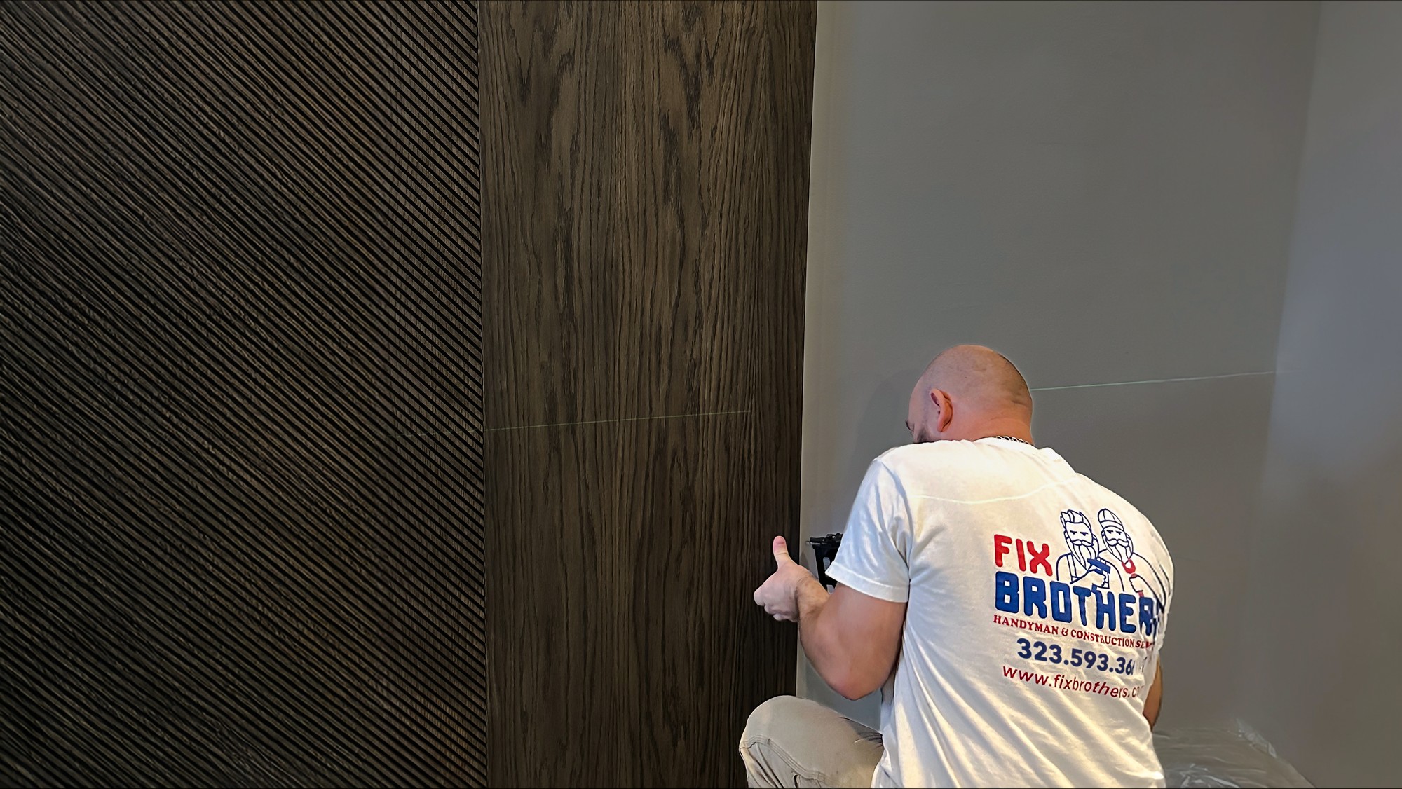Fix Brothers handyman installing a wood-look wall panel in a Los Angeles home