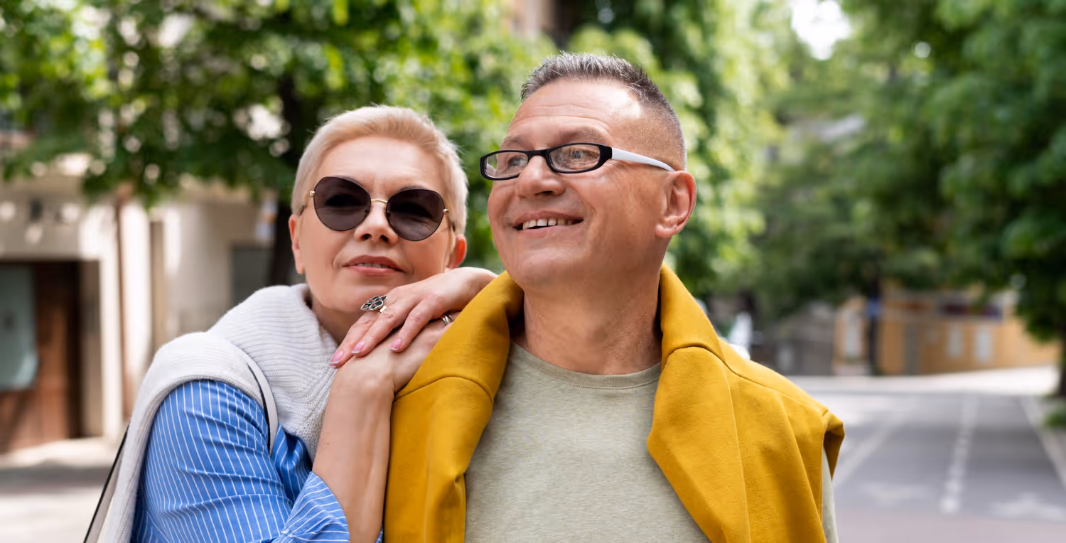 Happy mature couple smiling together outdoors in colorful clothing