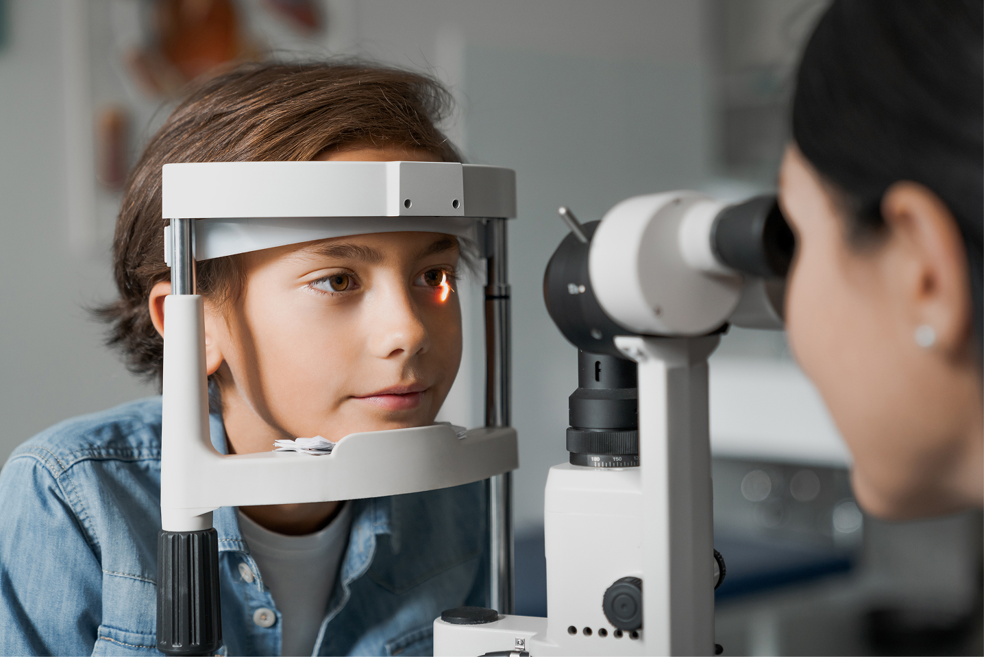 Child receiving eye exam with professional optical equipment