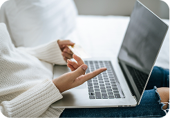 Person using a laptop with fingers poised over the keyboard.