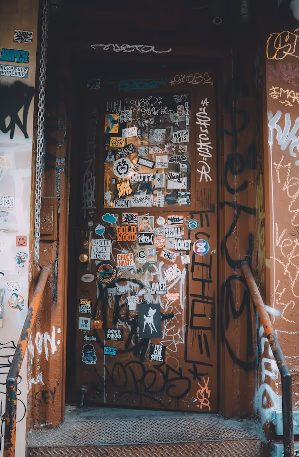 A door covered in stickers and graffiti.