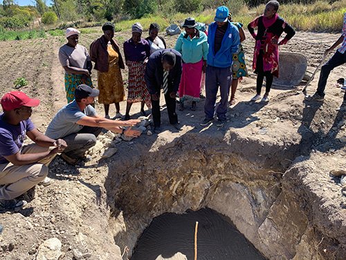 YWAM Perth Appropriate Technology Ministry team demonstrating a water system project to local villagers in a rural farming community.