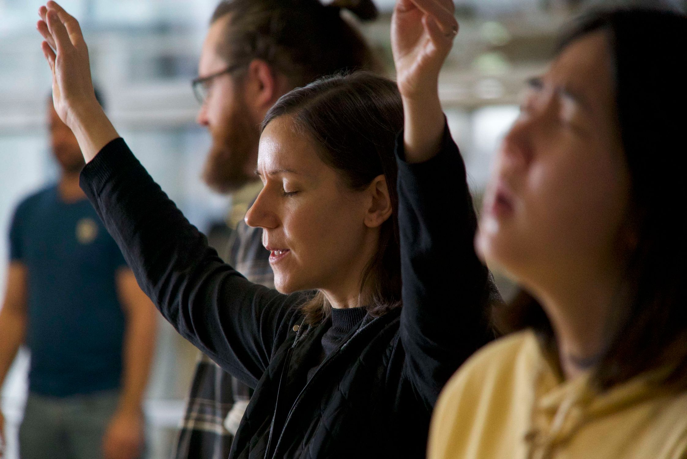 Group of people worshipping with hands raised during a live worship session