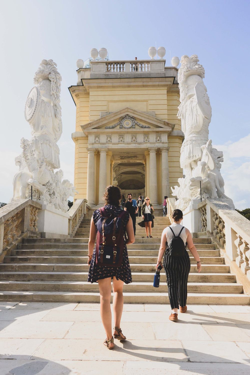 a group of people walk through a marble gate