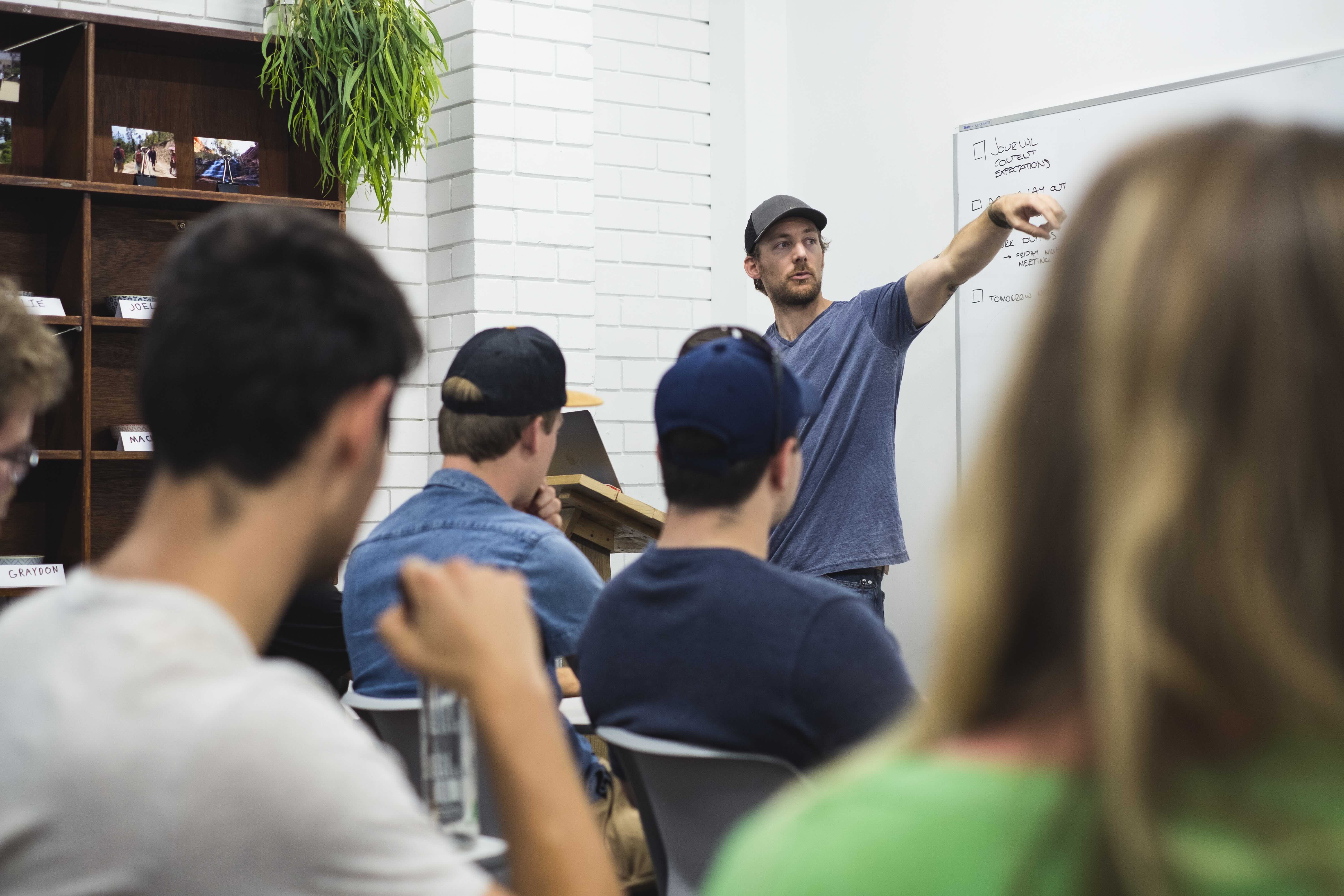 a male teacher teaches young people in a class