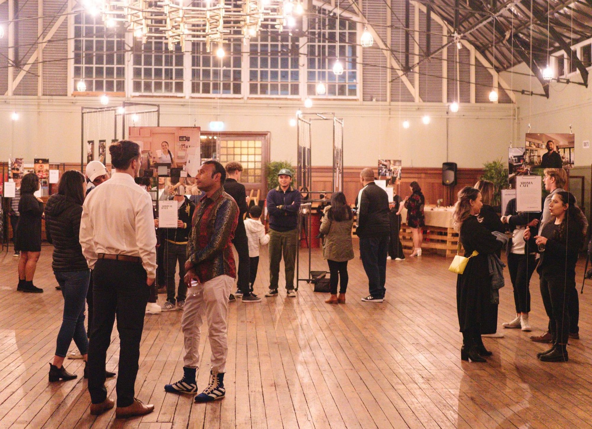 people talk at a photo exhibition in a gallery