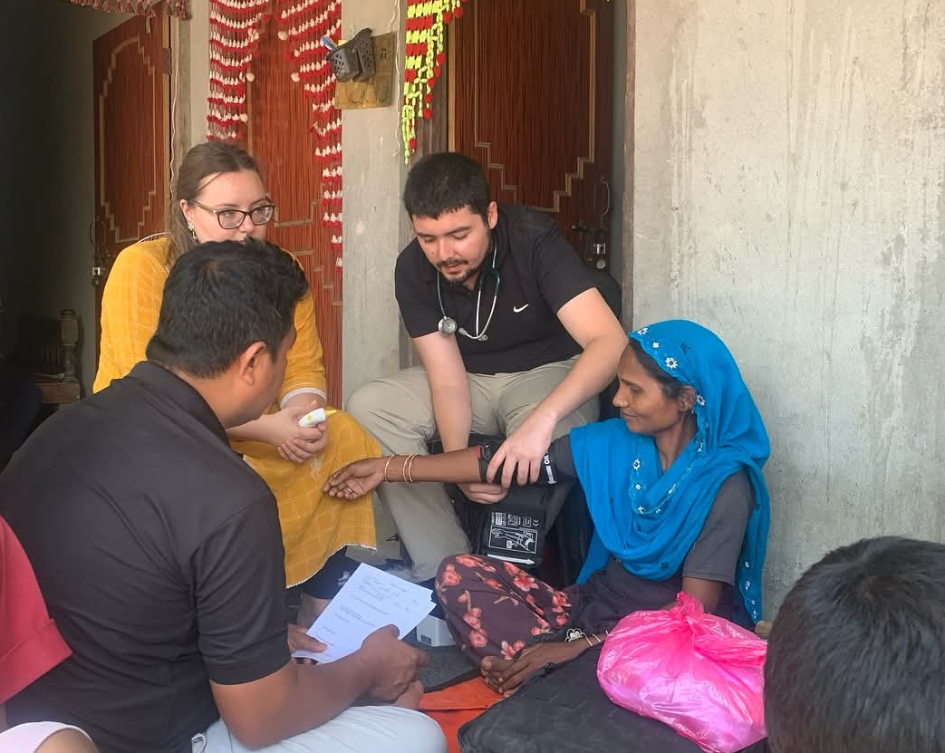 health care workers assist people outside of house 