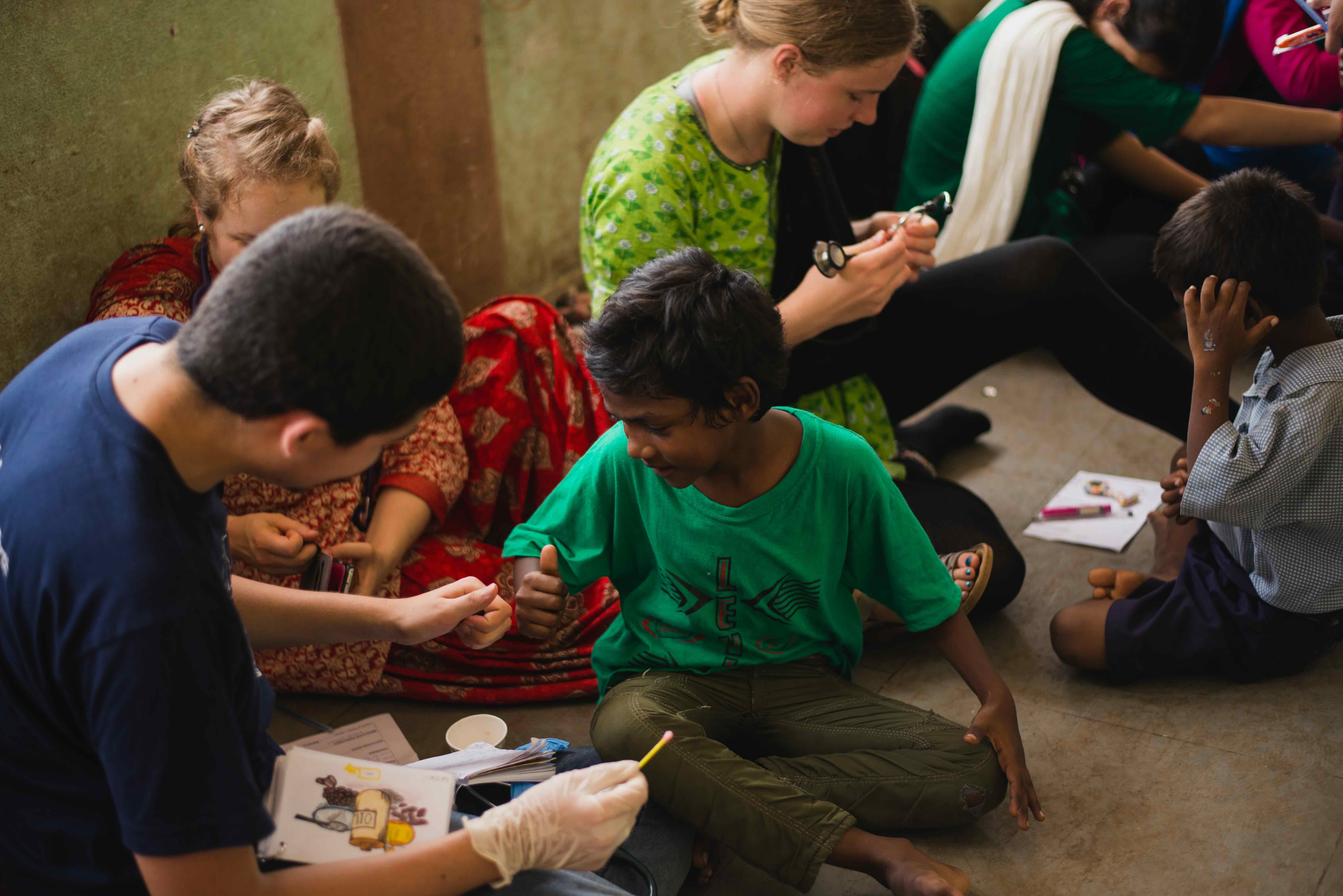 Health care workers help people in a rustic room