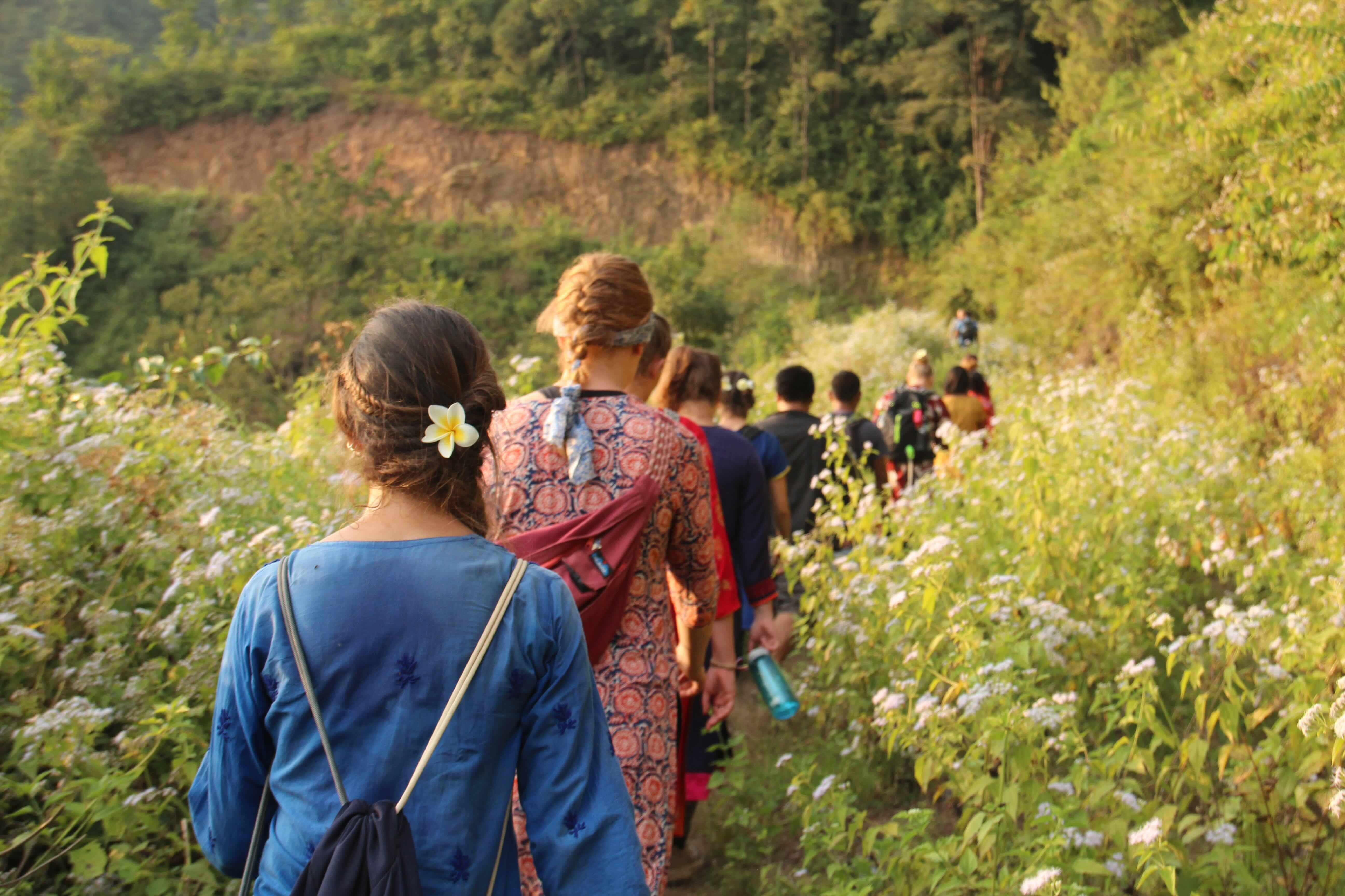 a line of young people trek through hills