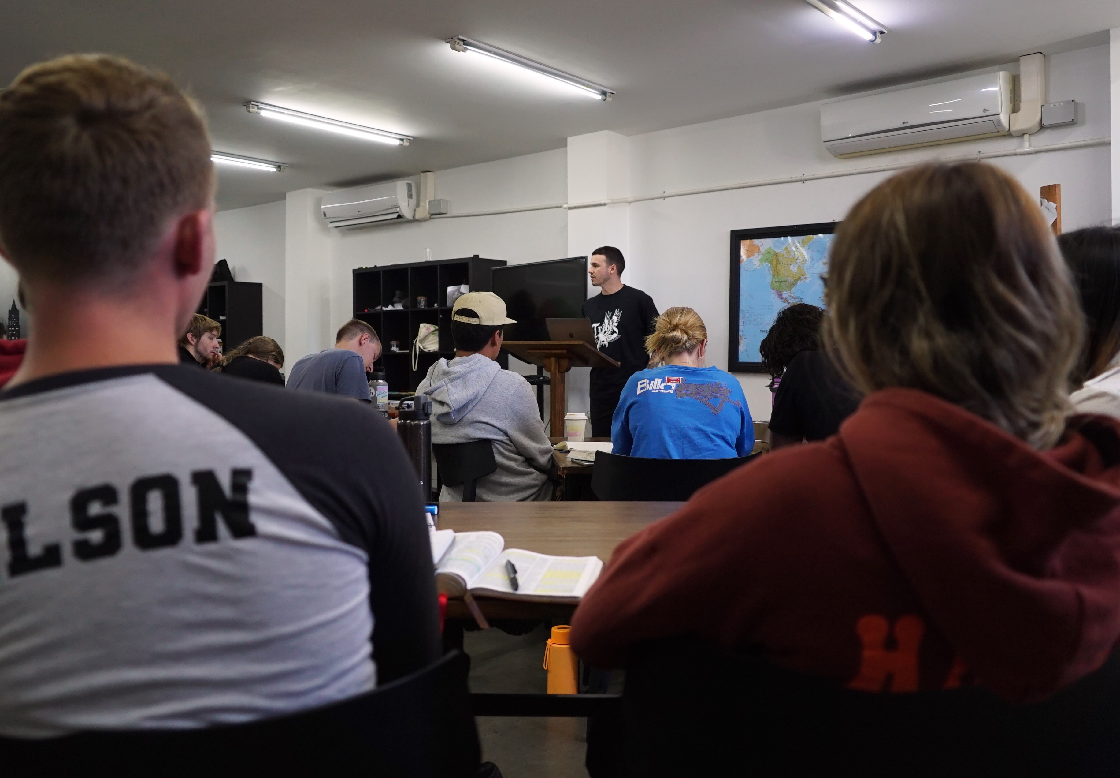 a teacher lectures a class of young adults