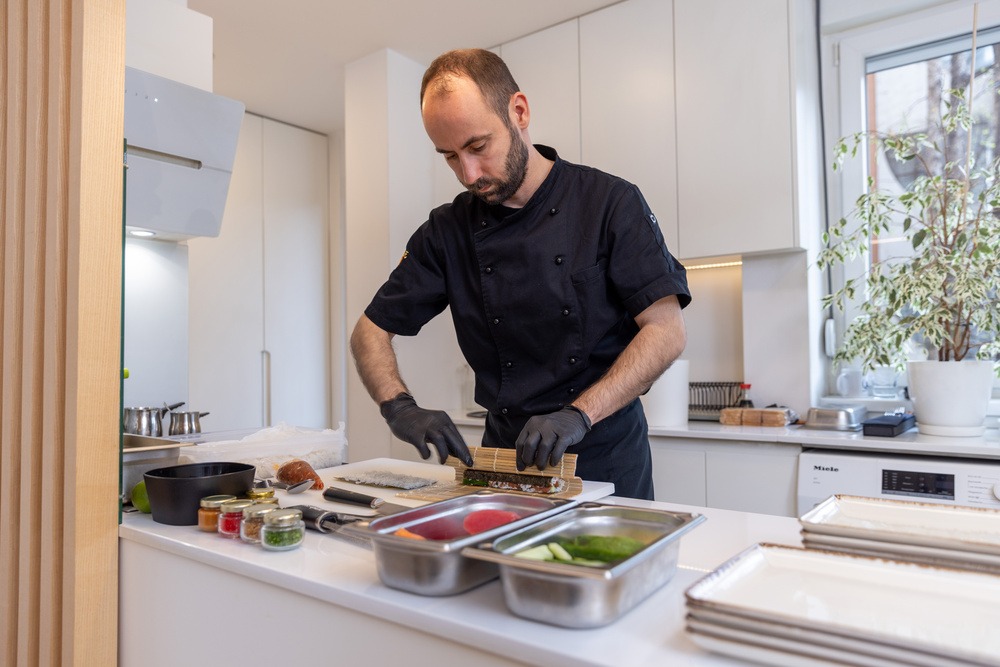 An elite private chef focused on his craft in a modern luxury kitchen, representing a placement by Montclair Chef.