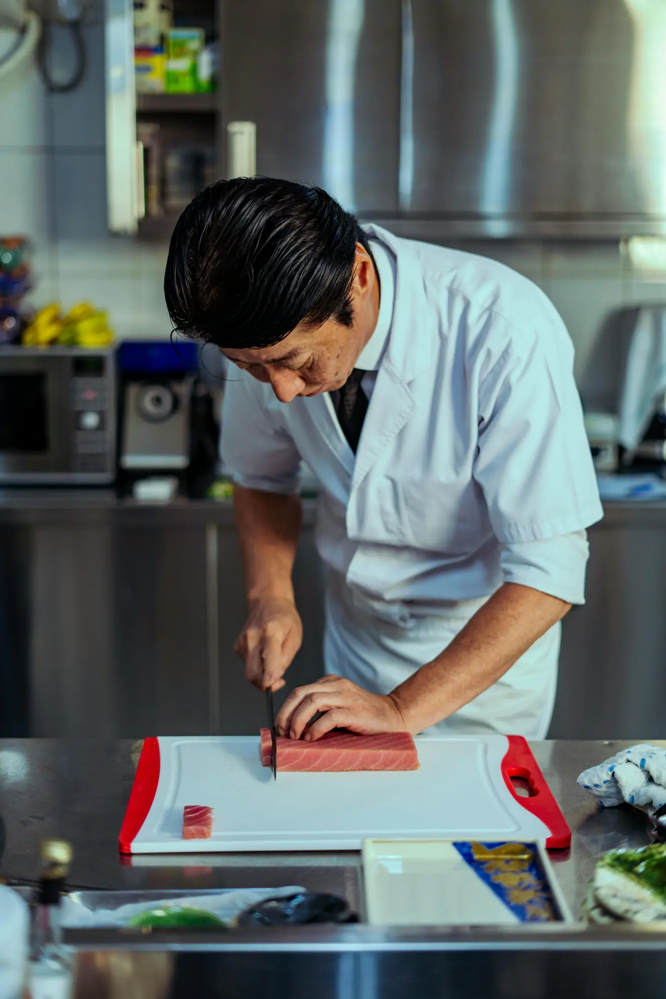 Expert Japanese chef slicing sushi-grade tuna with precision