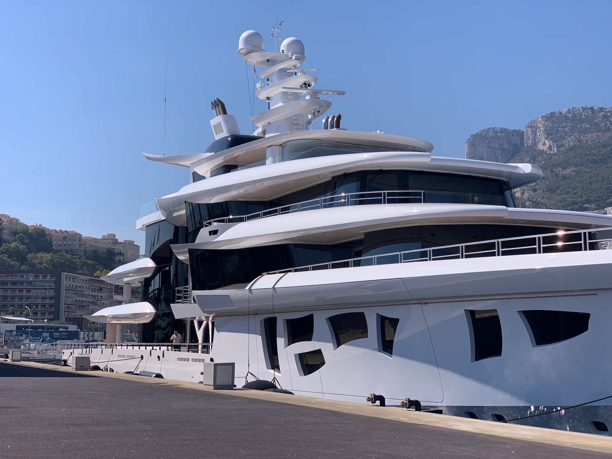 Ultra-modern white superyacht docked in Monaco, representing Montclair Chef's elite chef recruitment for high-performance charter yachts

