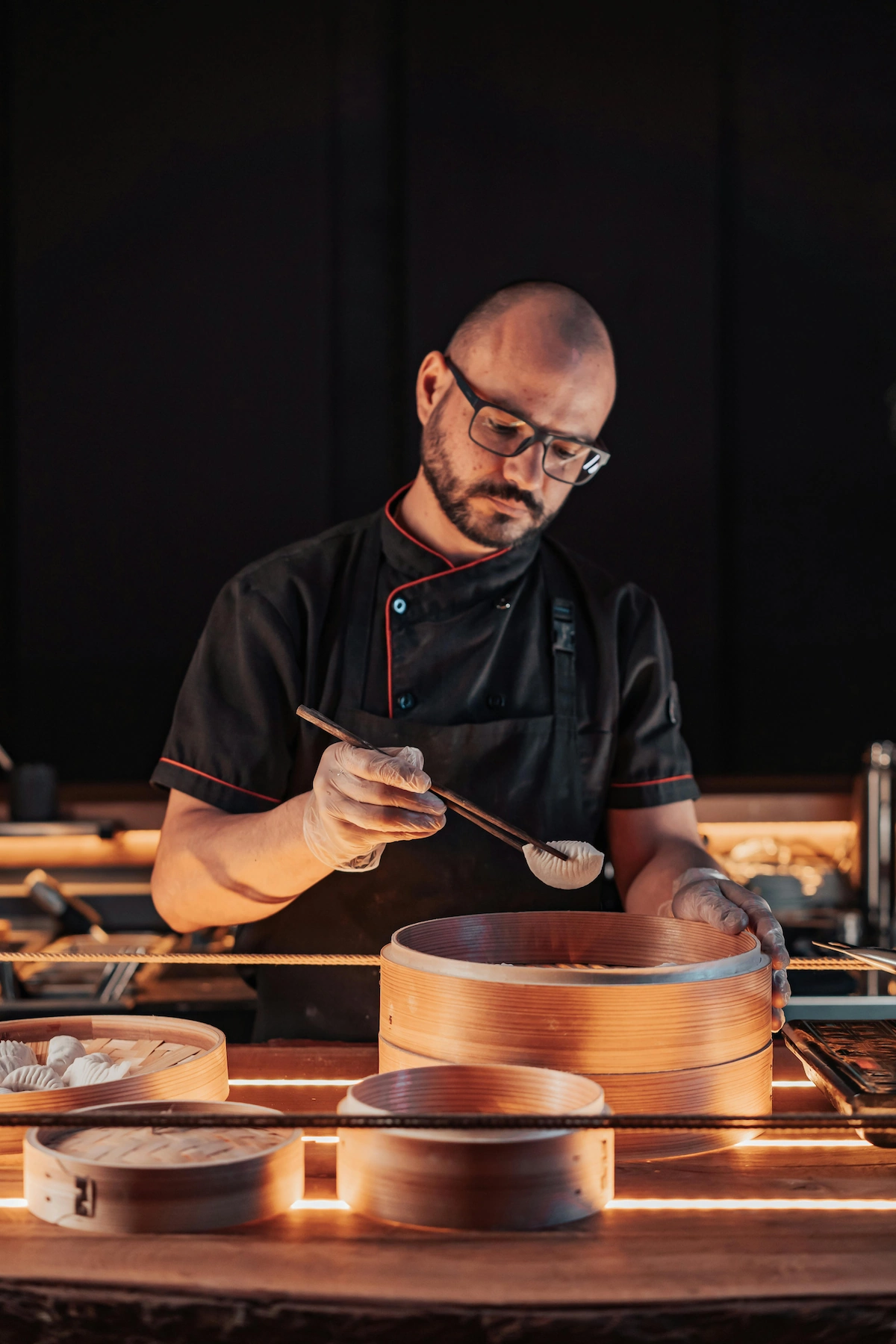 Michelin-trained private chef carefully plating gourmet cuisine for UHNW clients